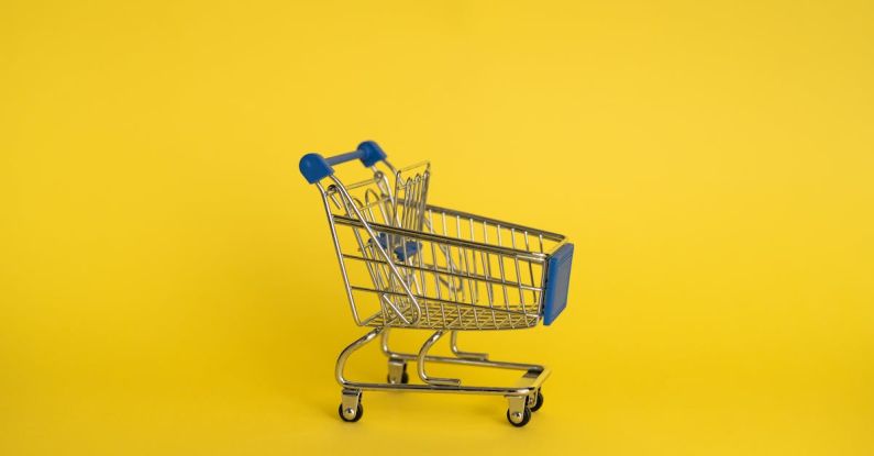 Retail Marketing - Isolated shining metal shopping trolley without anything located separately on yellow background