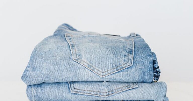 Market Trends - Pile of denim pants of different shades of blue placed on white shelf