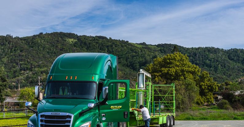 Logistics Efficiency - A green semi truck with a trailer parked on a dirt road