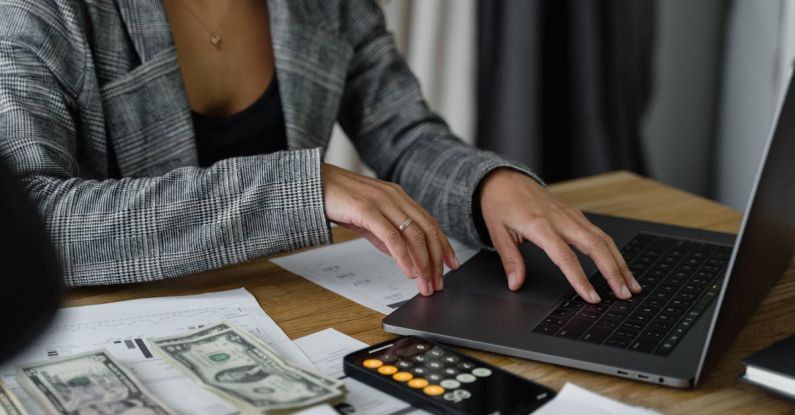 Manage Finances - A Woman in Plaid Blazer Using Her Laptop