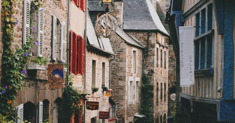 Infrastructure Investment - Narrow pedestrian street with brick residential houses in historic town district on cloudy day